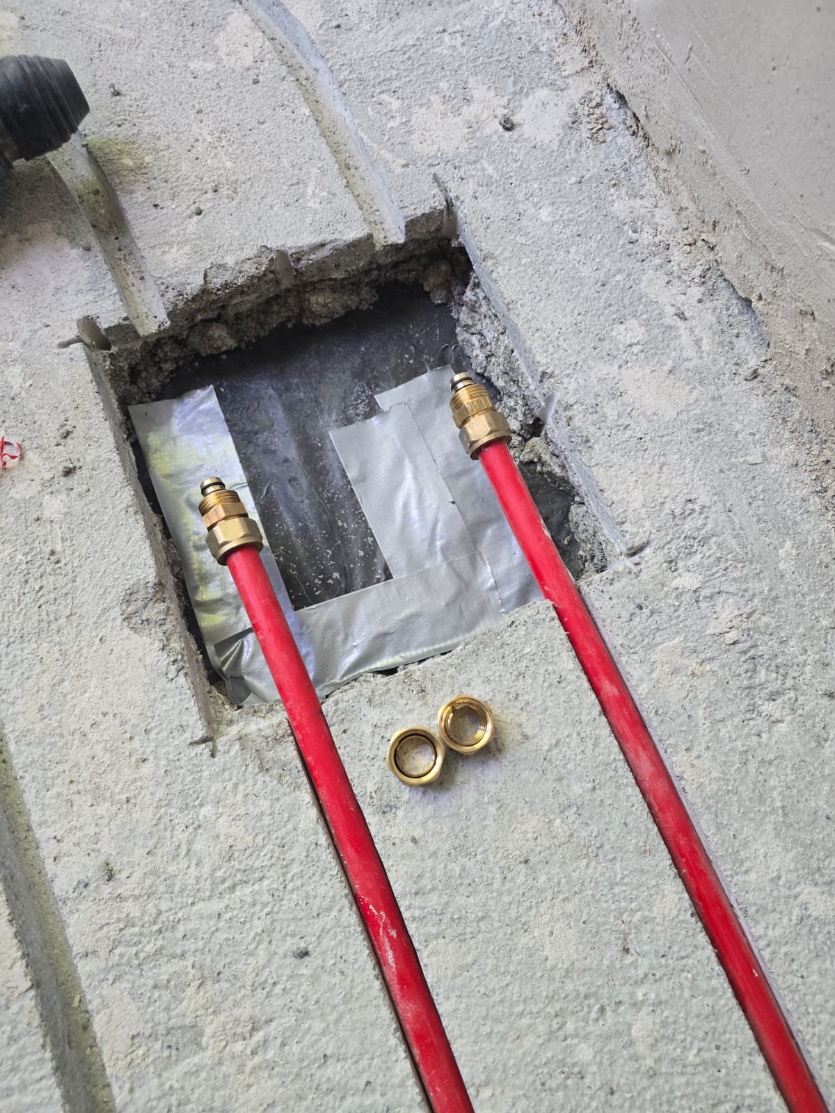 Vorbereitete Anschlussstelle mit roten Heizungsrohren